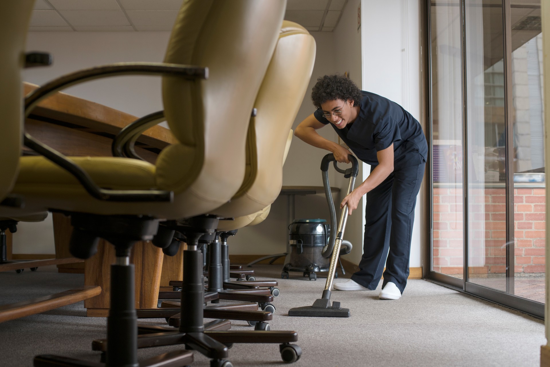 Man vacuuming the carpet of an office